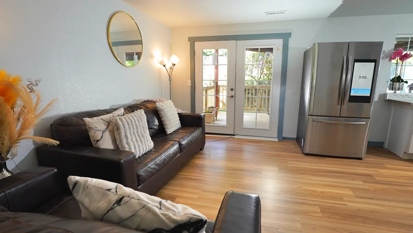 Main living room with leather sofas and French doors to the deck