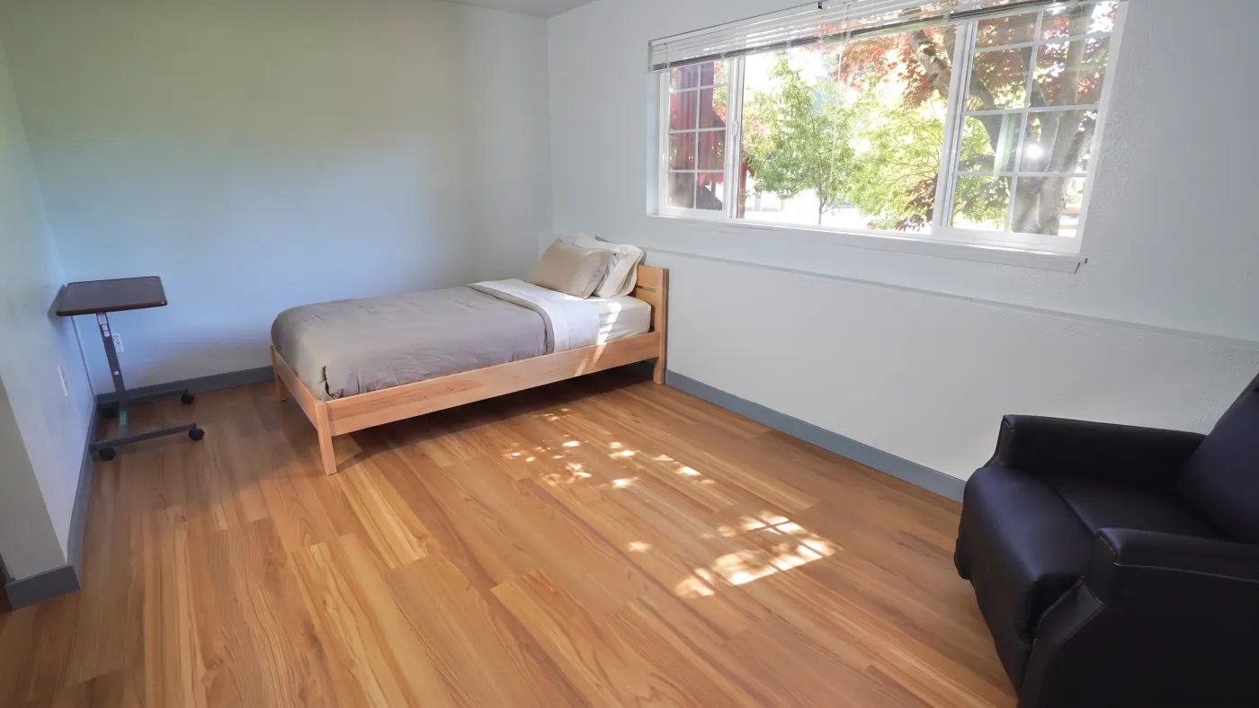 Quiet bedroom with adjustable bedside table and recliner