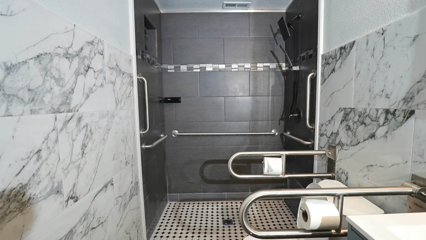 Roll-in tile shower with handheld fixture and grab bars
