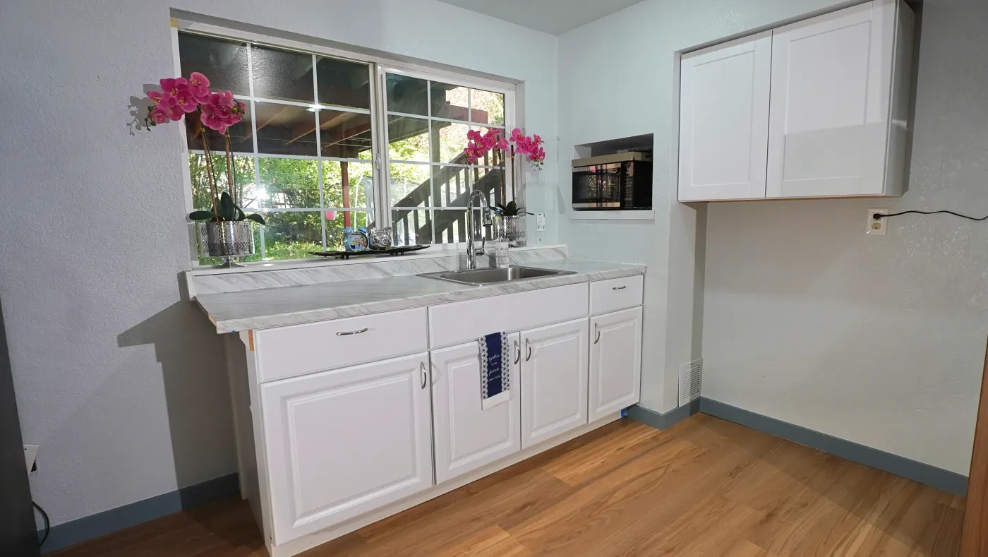 Kitchen sink and prep area decorated with orchids